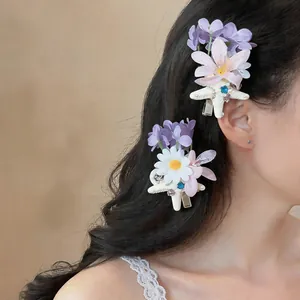 Detail view of French style fabric flower and starfish hair clips on wavy hair