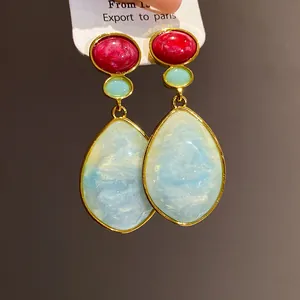 Elegant vintage resin teardrop earrings with blue marble texture and gold-plated frames.