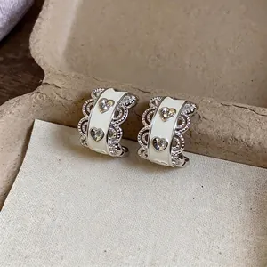Elegant silver heart earrings with white enamel coating and delicate lace edges for women