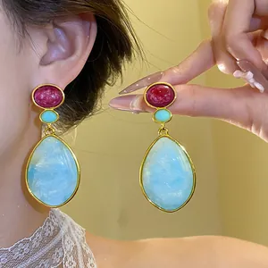 Detailed view of vintage resin waterdrop earrings with elegant gold-plated finish on model