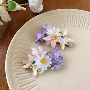 Detailed close-up view of elegant French fabric flower hair clips with starfish and pearl accents
