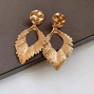 Detailed view of elegant gold pleated leaf drop earrings with a hammered texture finish