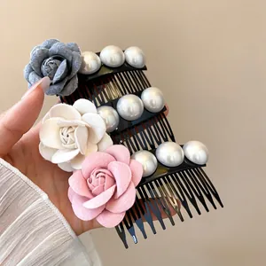Close-up detail of three elegant fabric flower hair combs decorated with white pearls