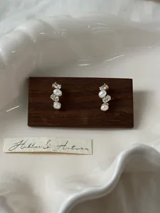 Detail of French style stud earrings featuring elegant pearls and sparkling zircons