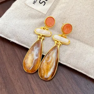 Close-up detail of vintage resin waterdrop earrings with an elegant gold-plated finish