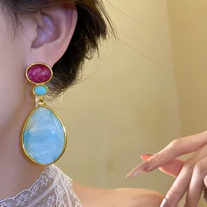 Detailed view of vintage-style resin teardrop earrings featuring light blue and pink accents