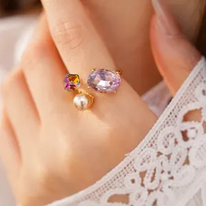 Elegant open ring with purple oval crystal, square iridescent stone, and white pearl