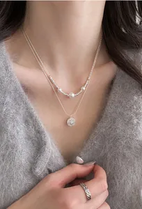 Detailed close-up of a elegant double-layered necklace with white pearls and star pendant