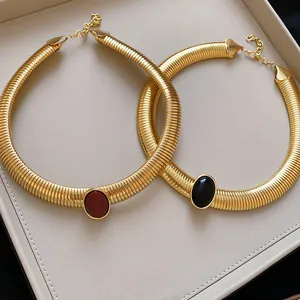 Détail du collier ras du cou vintage texture serpent dorée avec insert en résine ovale