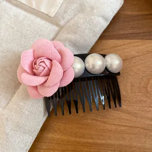 Detailed view of elegant French style pink fabric flower and faux pearl hair comb accessory