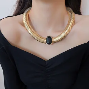 Gros plan d'un collier ras de cou vintage doré avec cabochon central en résine noire