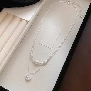 Elegant silver double-layer necklace featuring white pearls and a sparkling star pendant detail