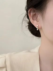 Elegant French style pearl and marquise zircon stud earrings shown on a model's ear