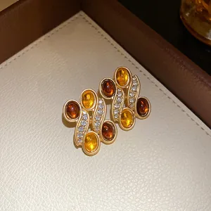 Detailed view of vintage amber resin earrings featuring sparkling rhinestones