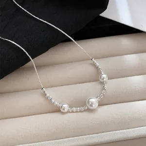 Close-up detail of an elegant pearl and textured silver bead necklace on a jewelry display.