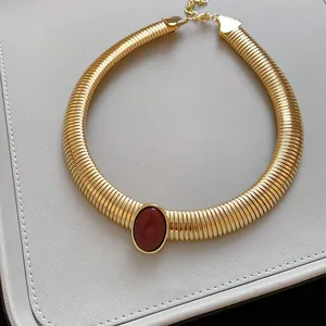 Zoom sur collier ras-du-cou vintage doré à motif serpent avec pierre en résine rouge