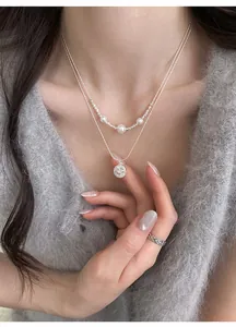 Elegant double-layered silver necklace with pearls and zircon star pendant detail