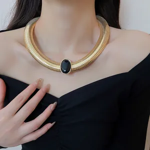 Gros plan du collier ras de cou vintage en spirale dorée avec pierre en résine noire