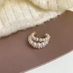 Κομψό σκουλαρίκι ear cuff με τρεις σειρές πέρλες σε χρυσό χρώμα χωρίς τρύπα, μοντέρνο στυλ.