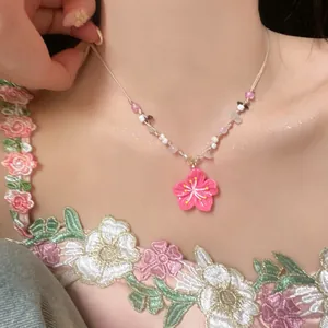 Close-up of a colorful beaded dopamine necklace with a pink flower pendant detail