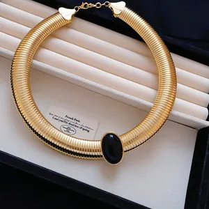 Vue détaillée d'un collier ras-du-cou doré torsadé avec une pierre ovale en résine noire