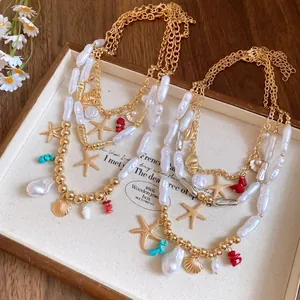 Detailed view of layered pearl necklace with golden starfish and seashell charms