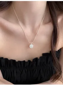 Elegant silver necklace with a zircon star pendant worn by a model in a close-up detail shot.