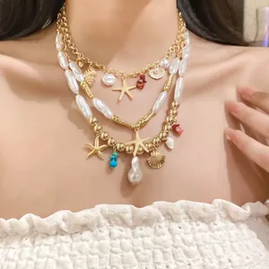 Detail showing multi-layer gold chain necklace with pearls and starfish charms