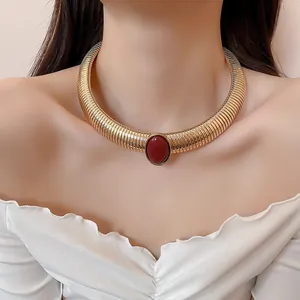 Collier ras-de-cou doré vintage à texture spirale avec pierre en résine rouge ovale.