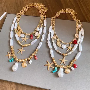 Detailed view of layered gold necklaces featuring baroque pearls, starfish and sea shell charms