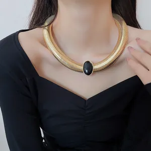 Détail du tour de cou serpent doré vintage avec pierre ovale en résine noire.