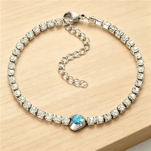 Detailed view of silver tennis bracelet with clear zircons and blue heart stone