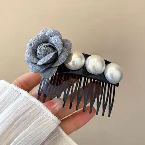 Detailed close-up of a French style cloth flower and pearl hair comb accessory in grey