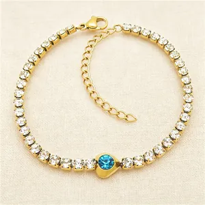 Detailed macro view showing the blue heart crystal on a gold-plated tennis bracelet