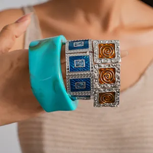 Close-up of vintage enamel square elastic bracelets and turquoise resin bangle on model wrist.