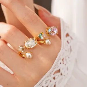 Close-up detail showing the arrangement of crystals and pearls on a gold-plated open ring.