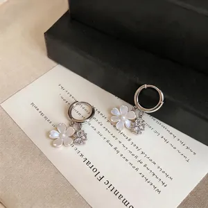 Silver hoop earrings with delicate shell flower and sparkling zircon clover charms