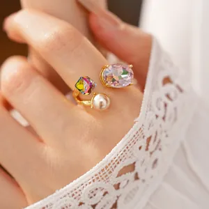 Detailed macro view of an open ring featuring oval purple crystal, square stone and pearl.