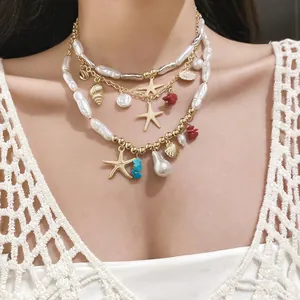 Close-up detail of a layered necklace with baroque pearls and gold starfish charms.