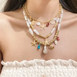 Close-up view of a layered gold necklace featuring pearls and starfish charms on a model