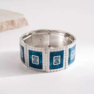 Detailed view of retro silver-tone elastic bracelet with blue enamel spiral panels