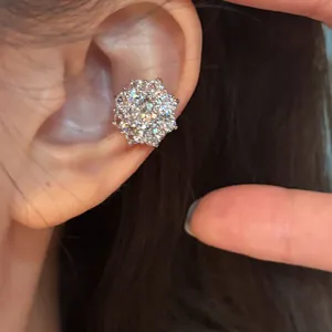 Gros plan détaillé d'un ear cuff fleur en zircone étincelante porté sur l'oreille