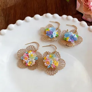 Boucles d'oreilles fleurs dorées creuses style vacances avec fleurs en résine
