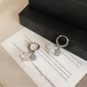 Detailed close-up of elegant silver hoop earrings featuring white pearl flower and zircon charms