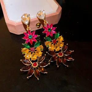 Close-up of colorful floral statement earrings with vibrant sparkling rhinestones