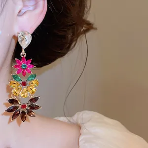 Close-up detail of oversized multi-colored rhinestone floral drop earrings for women