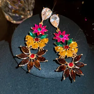 Detailed close-up of oversized colorful floral rhinestone earrings with brilliant sparkle.