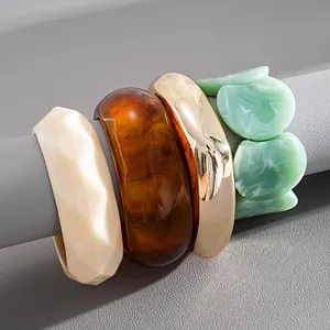 Détail d'un ensemble de bracelets géométriques en acrylique marbré et ton doré chic