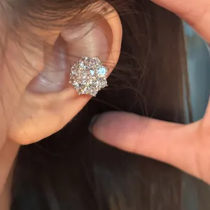 Vue détaillée d'une boucle d'oreille fleur en oxyde de zirconium sur l'oreille d'un modèle