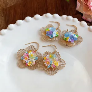 Gros plan détaillé de boucles d'oreilles créoles fleurs avec pétales filigranes dorés